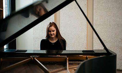 female student playing a piano